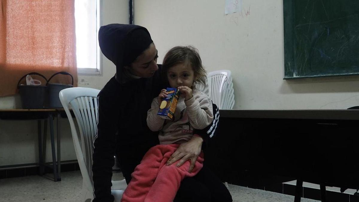 Farah con una de sus hijas, en un aula de la escuela donde se encuentran refugiadas.