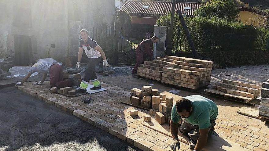 Obreros trabajando en el entorno del consultorio de Caravia, ayer.