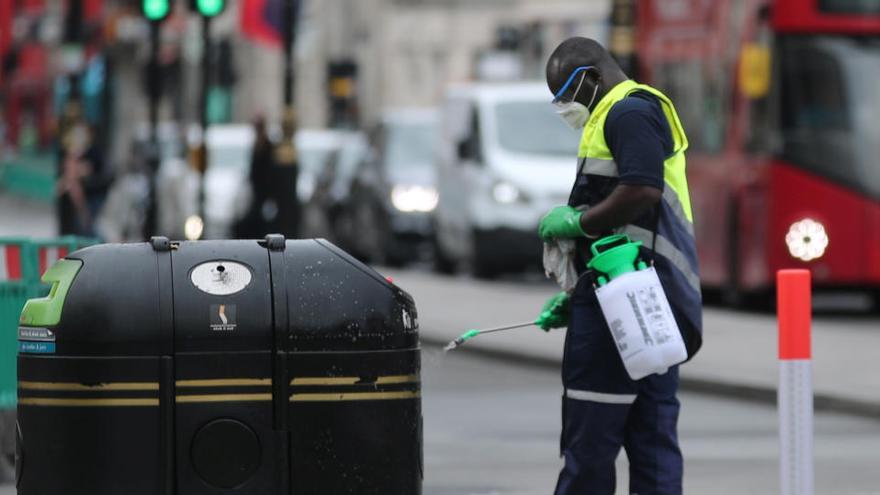 Un trabajador desinfecta una papelera en Londres.