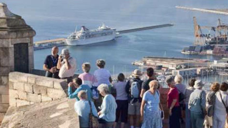 Turistas contemplando el puerto de Alicante desde lo alto del castillo de Santa Bárbara.