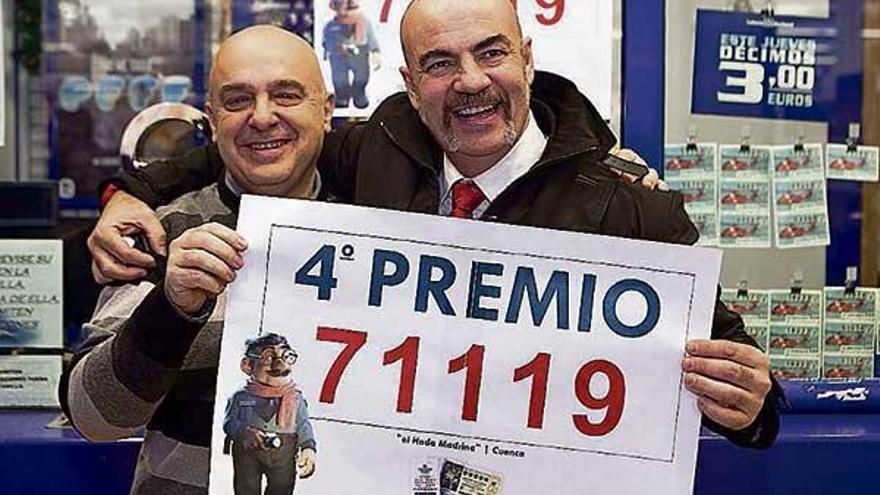 Dos administradores conquenses con el cartel del cuatro premio. | efe