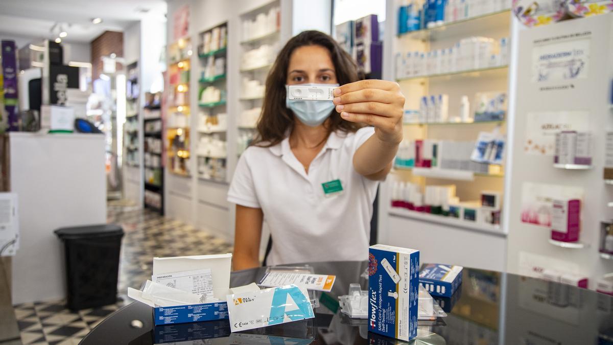 Una farmacéutica posa con un test de antígenos.