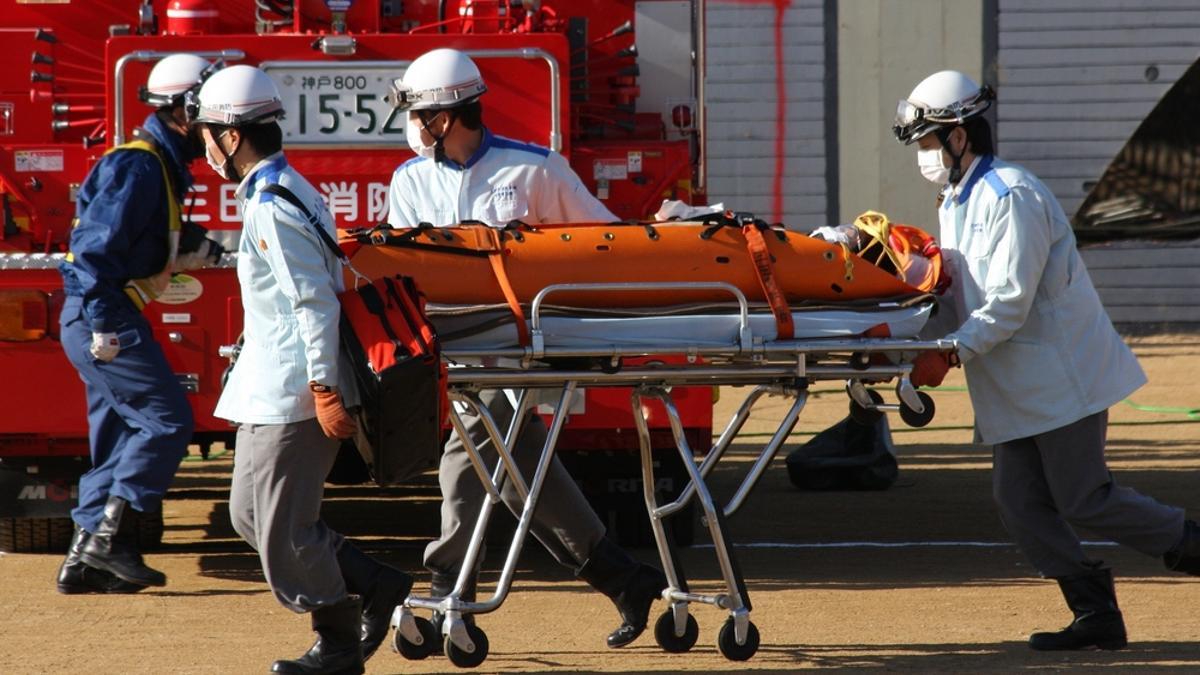 Sanitarios llevan a un herido a una ambulancia en Japón.