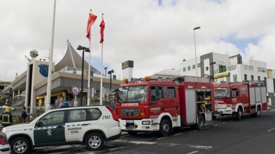 Bomberos a la entrada del centro comercial Biosfera y sobre estas líneas el cuarto donde se produjo el cortocircuito. i NICO MELIÁN