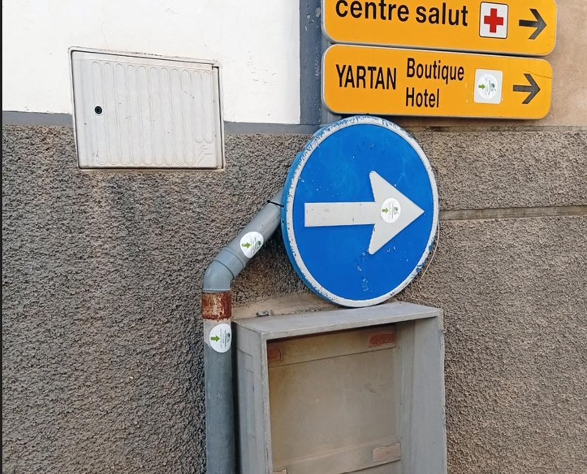 Pegatinas de la organización en carteles y señales de tráfico.