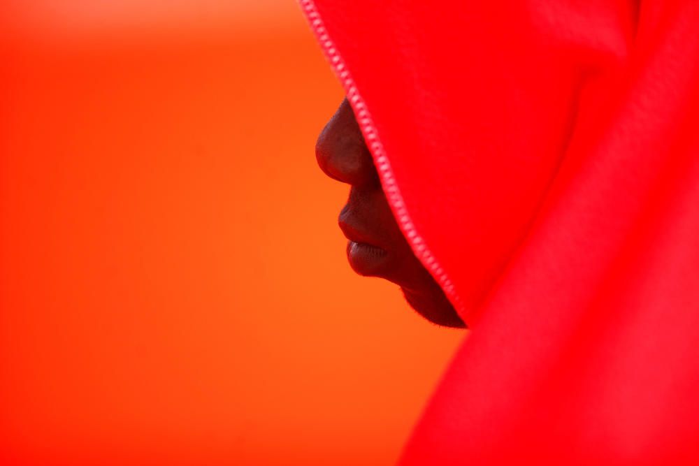 Migrant rests on a rescue boat upon arrival at ...