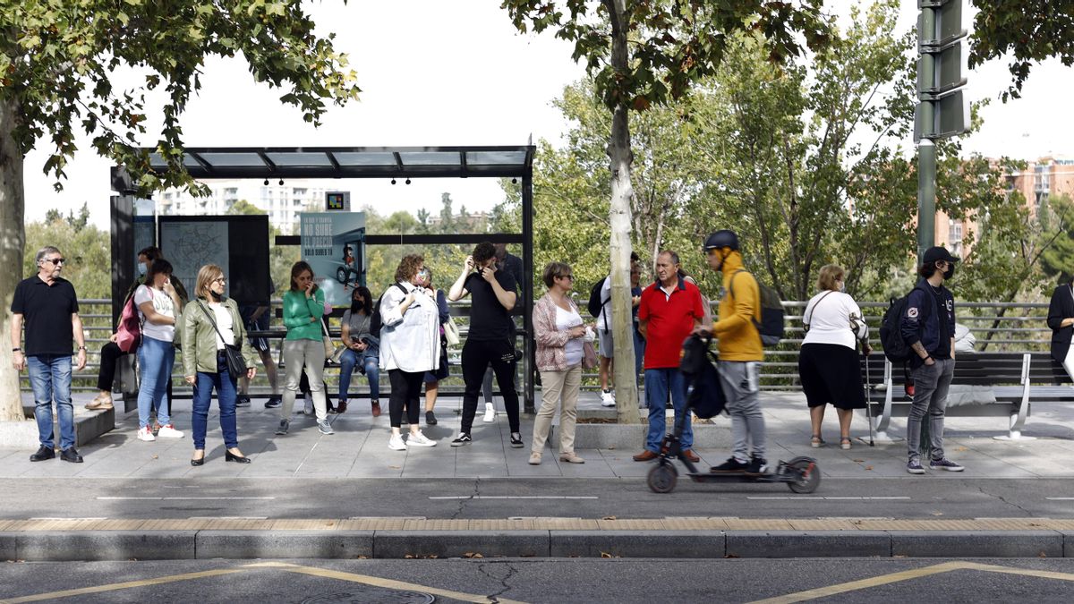 Personas esperando en una parada del autobús urbano de Zaragoza en una de las horas de paro.