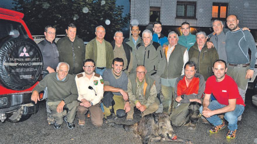 La cuadrilla de Fernando Martínez, acompañada de Benjamín Noval y los guardas, con el jabalí capturado. | J. E. C.