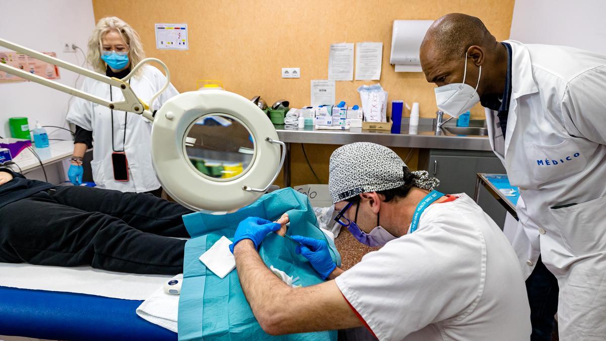 Un médico practica una cirugía menor en un centro de salud de la provincia