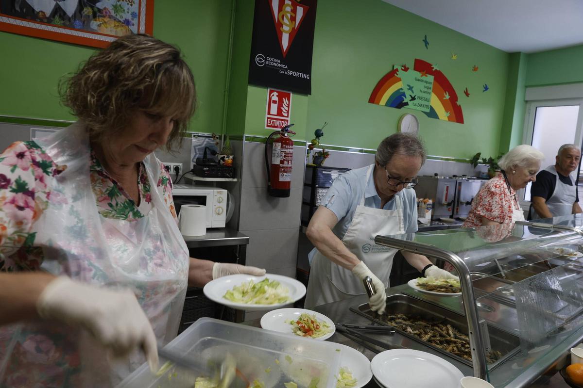 Integrantes de la Cocina Económica, preparando platos en el comedor.