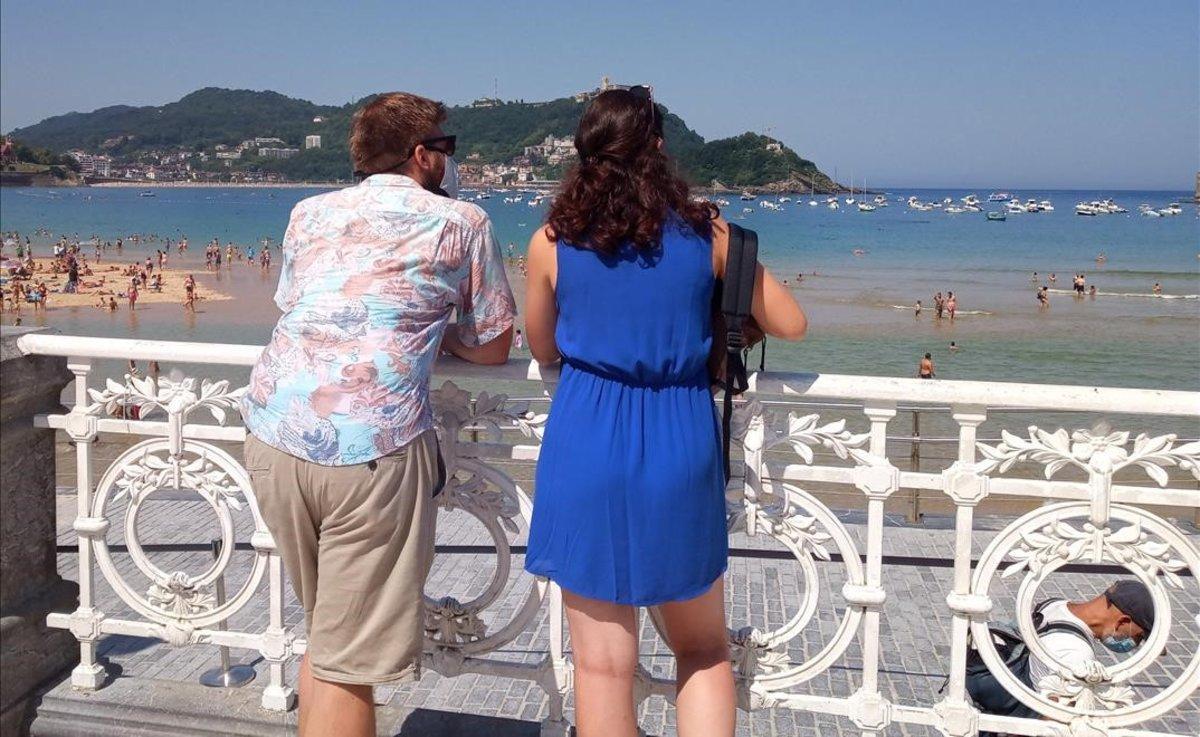 Una pareja contempla las vistas de la playa de la Concha, en San Sebastián, en un día en el que se espera que las temperaturas lleguen a los 37 grados en el País Vasco.