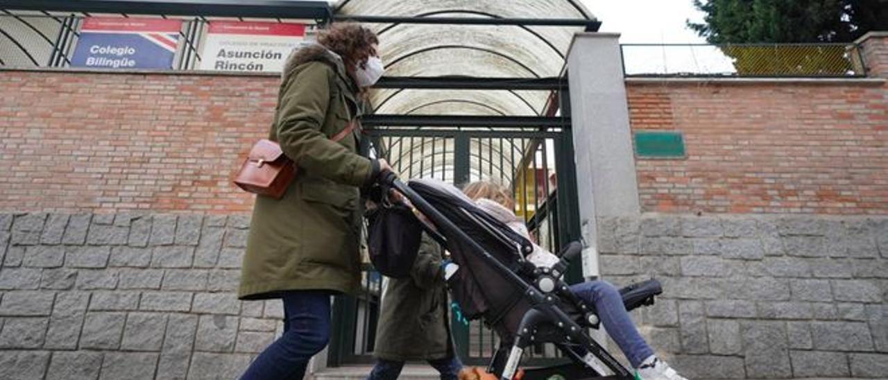 Una madre, con sus dos hijos, a la puerta de un colegio público, en Madrid.