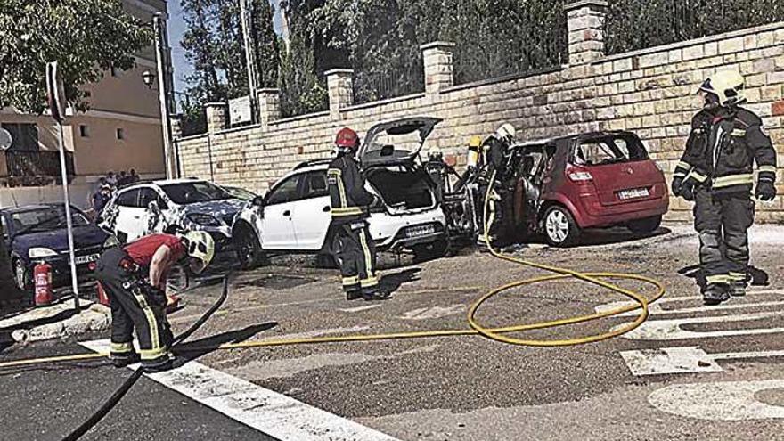 Varios bomberos, junto a los dos coches afectados.