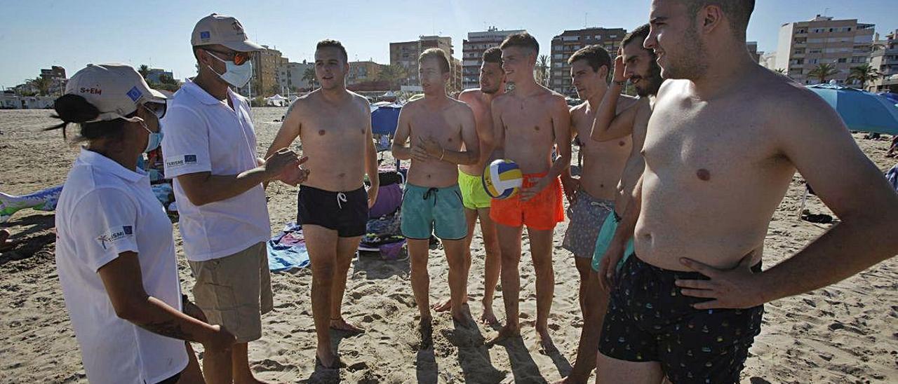 Dos informadores, en pleno trabajo en la playa de Port de Sagunt.