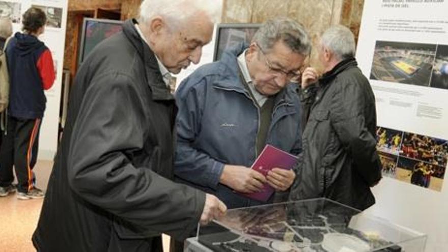 Dos visitants observen la maqueta del projecte de remodelació del Camp Nou