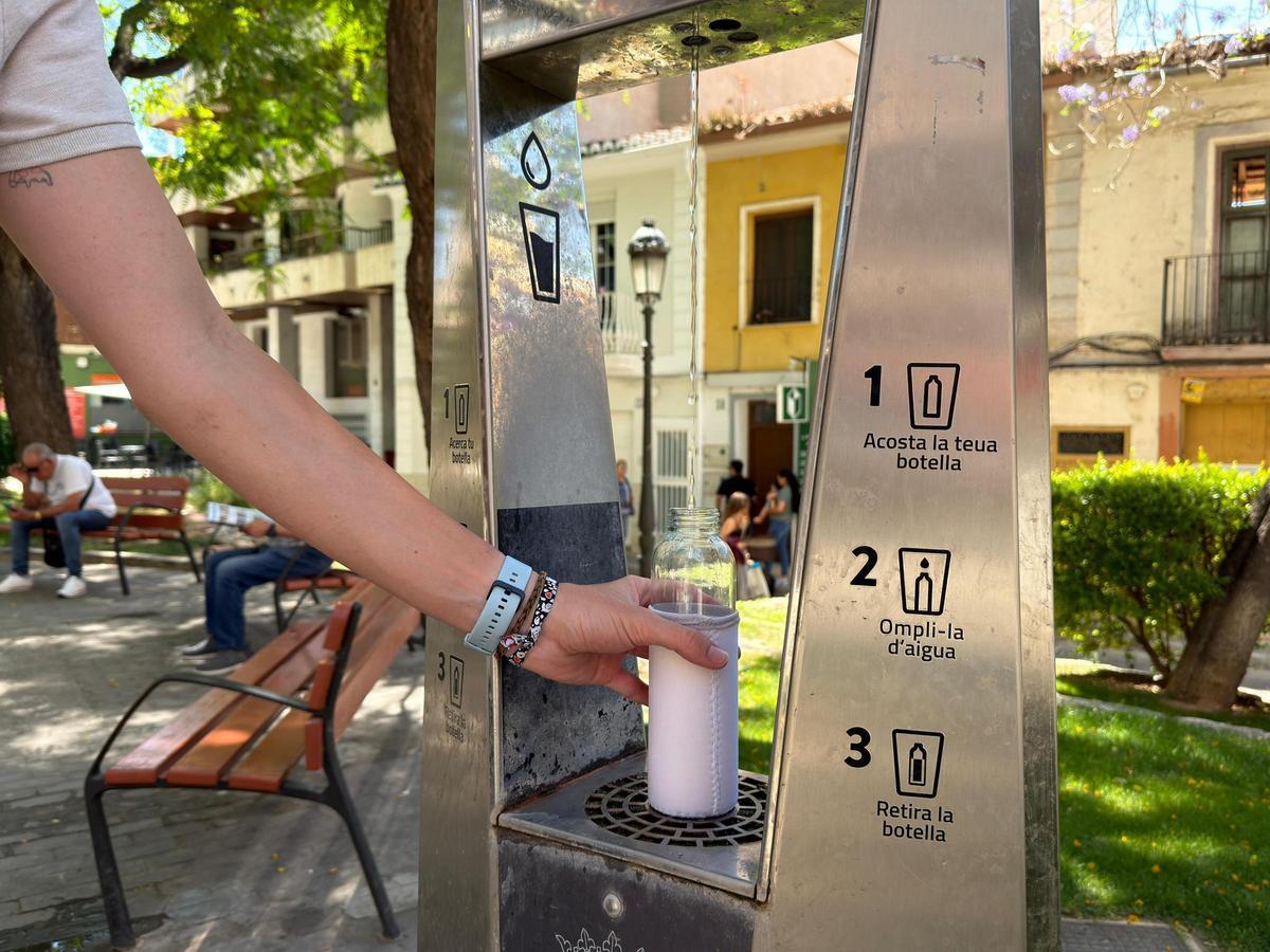 Un vecino llena su botella en una de las fuentes.