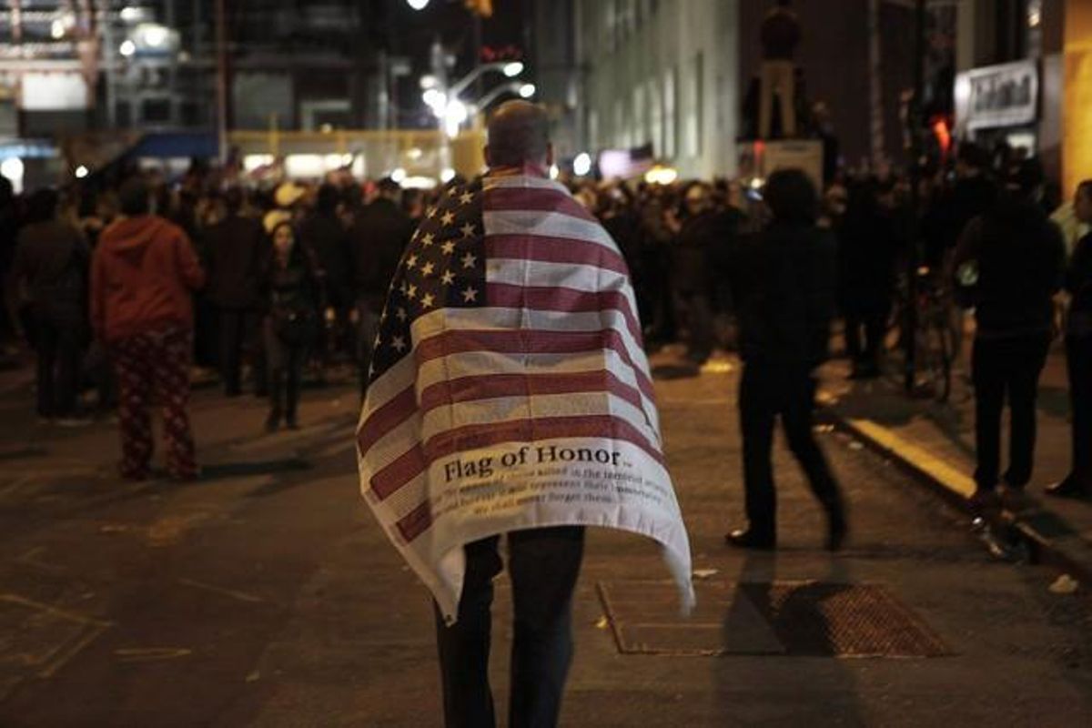 Un home camina per la zona zero de Nova York embolicat en una bandera americana, durant les celebracions per la mort d’Ussama bin Laden.