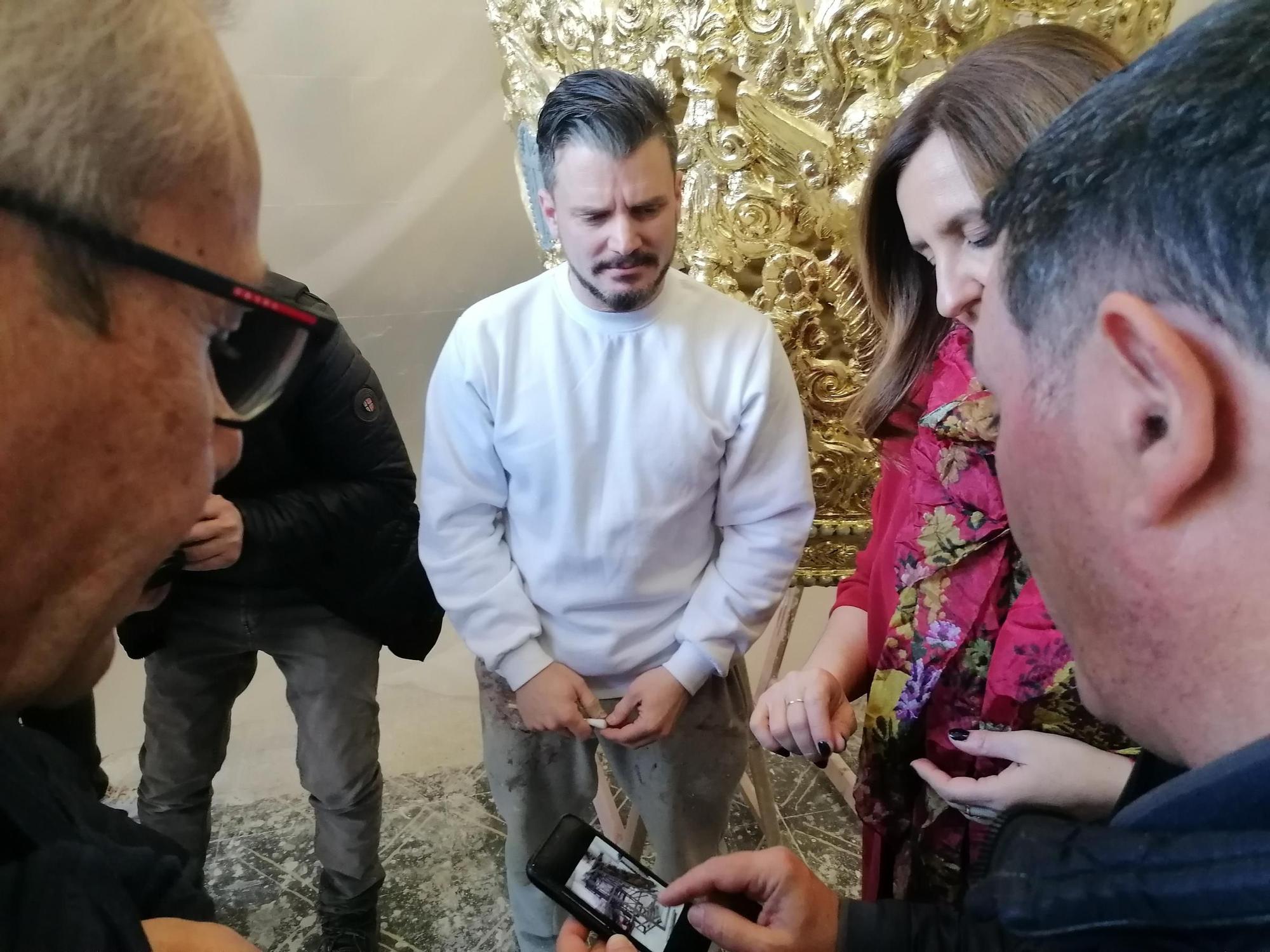 Uno de los artistas y la alcaldesa colocan pan de oro en la corona de la Mare de Déu.