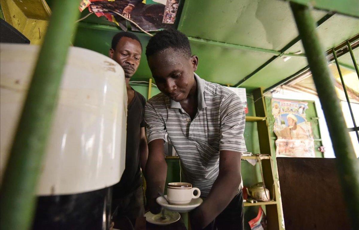 Alphonse Yeo Navigue, amputado de las dos manos, trabaja en un puesto de café, en Abidjan, Costa de Marfil.