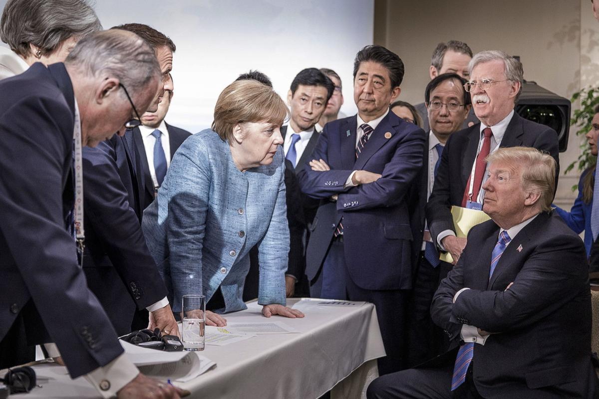 JD100. Charlevoix (Canada), 09/06/2018.- A handout photo made available by the German Government (Bundesregierung) on 09 June 2018 shows French President Emmanuel Macron (3-L, partially hidden), German Chancellor Angela Merkel (C-L) and Japan’s Prime Minister Shinzo Abe (C-R) speaking to US Presidend Donald J. Trump (R, seated) during the second day of the G7 meeting in Charlevoix, Canada, 09 June 2018. Looking on is US National Security Advisor John R. Bolton (R, standing); others are not identified. (Japón) EFE/EPA/JESCO DENZE HANDOUT HANDOUT EDITORIAL USE ONLY/NO SALES