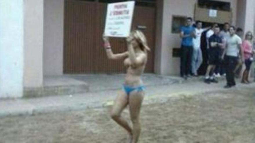 Una mujer en topless anuncia un cartel taurino