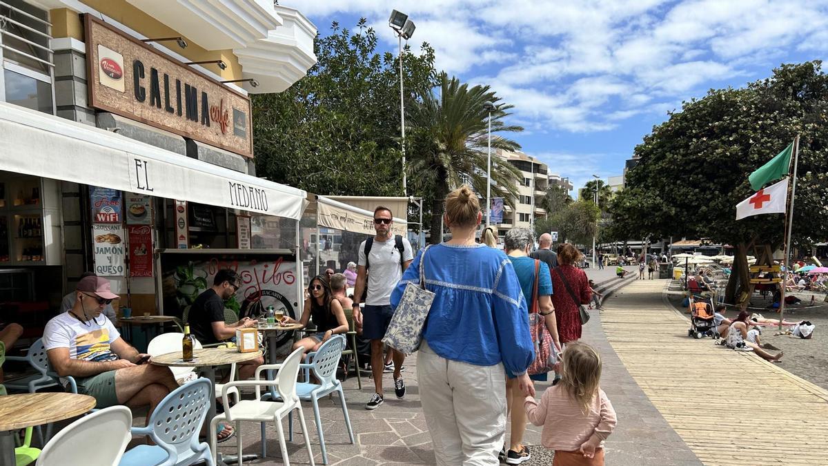 Turistas caminando por el paseo de la playa de El Médano en Tenerife