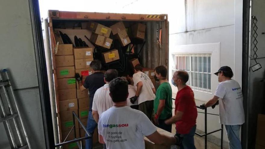 Grupo de voluntarios cargando uno de los contenedores.