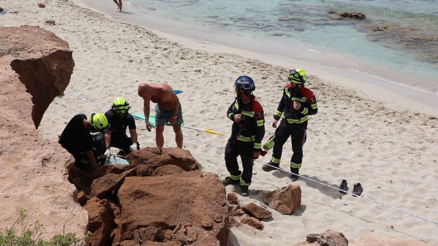 Los bomberos inspeccionan la cornisa que se desprendió y aplastó a un padre y a su bebé de dos meses en la playa de es Copinar, en Formentera. | CARMELO CONVALIA