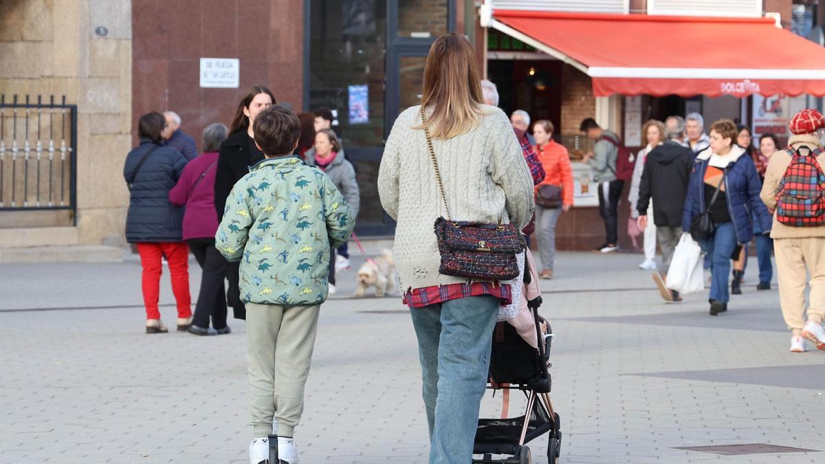 Una mujer pasea con sus hijos por Vigo