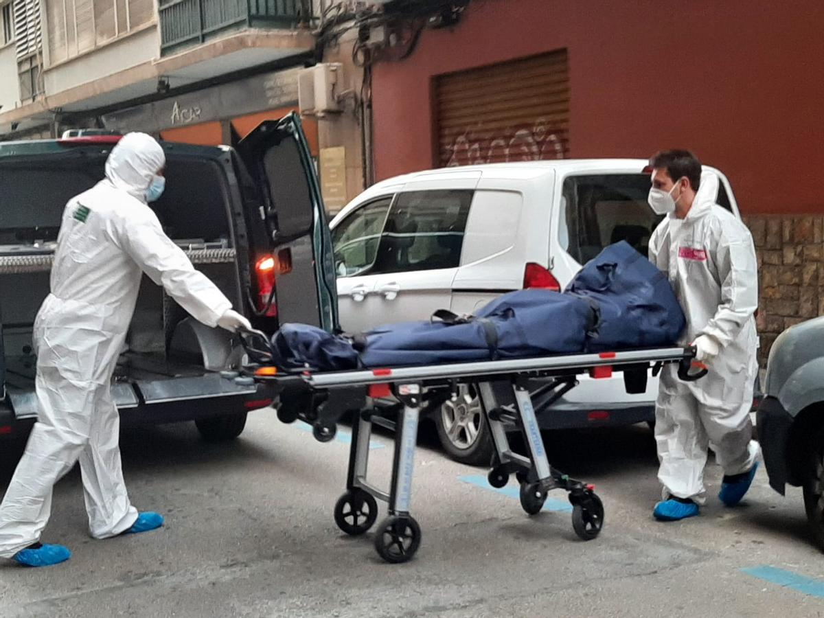 Empleados de la funeraria sacan uno de los cadáveres hallados en un domicilio de es Camp Redó (Palma)