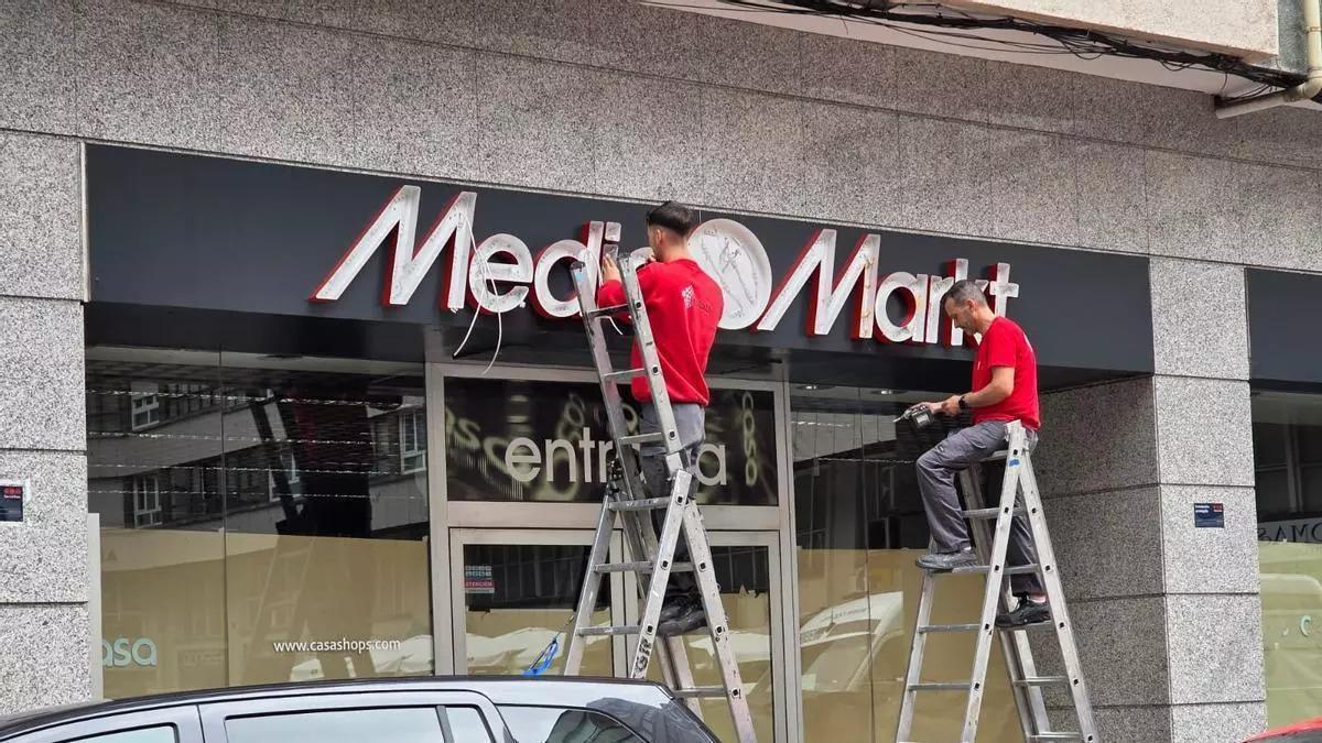 Los operarios colocan el rótulo del próximo Media Markt en la calle José Cueto.