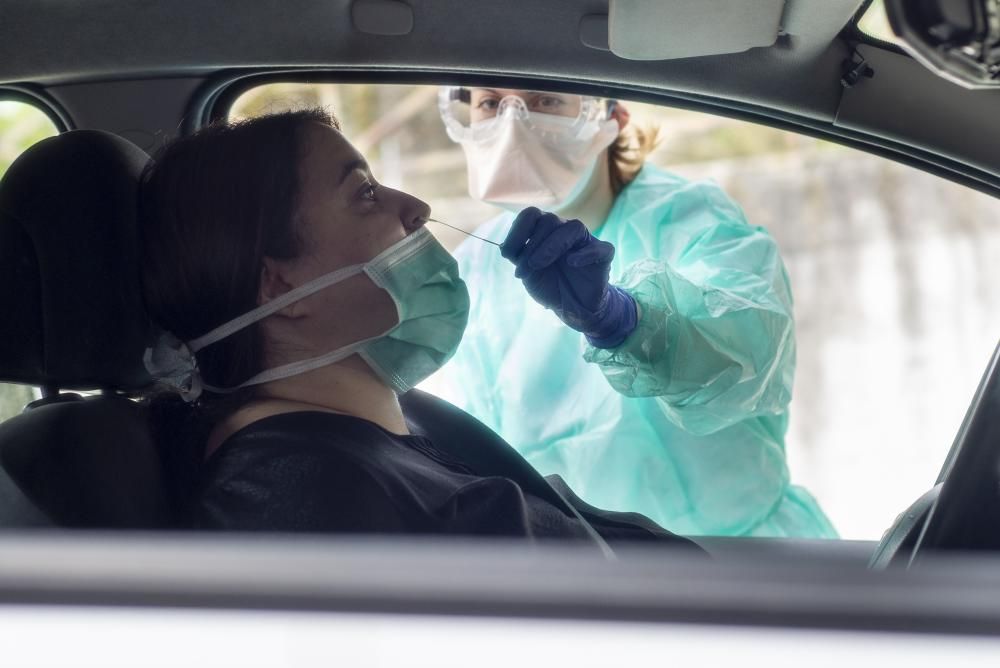 Una enfermera del CHUO realiza una prueba a una mujer en la zona habilitada para el test del coronavirus. // Carlos Peteiro