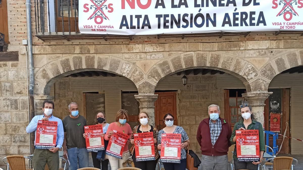 Miembros de la plataforma posan junto a la pancarta colocada en la junta agropecuaria