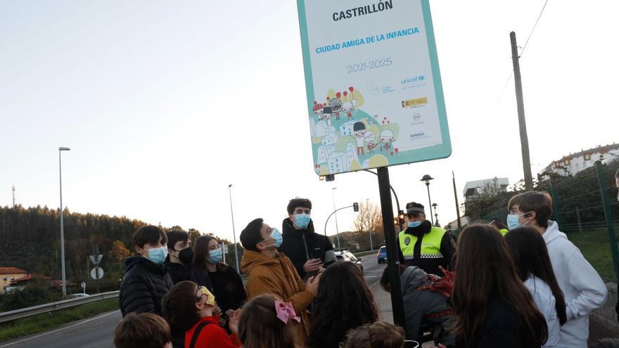 Un grupo de niños y jóvenes en 2021, ante la placa que acredita a Castrillón como Amigo de la Infancia. | M. V.