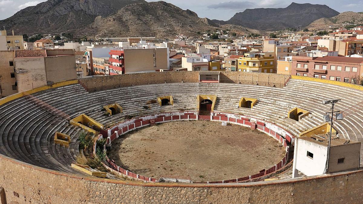 Matorrales y arbustos crecen en el albero y las gradas de la plaza de toros de Elda tras permanecer cinco años cerrada por problemas de seguridad en la estructura.