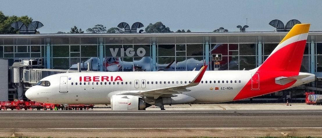 Un avión de Iberia frente al edifico terminal del aeropuerto de Vigo.