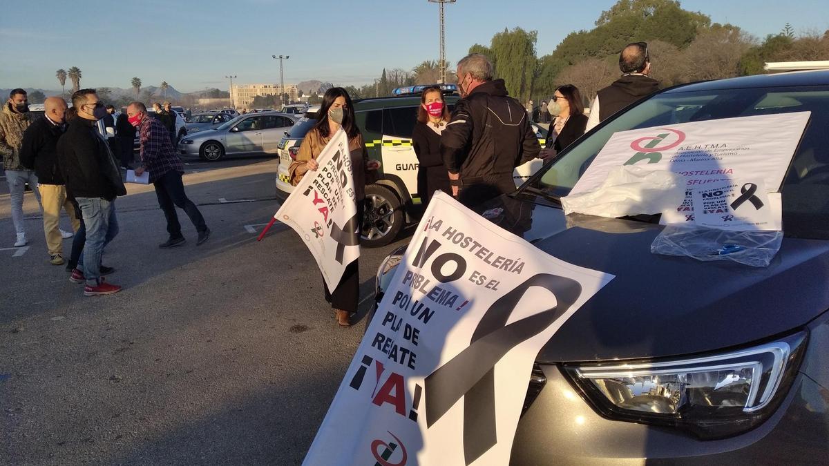 Los manifestantes colocan las pancartas en los coches antes de iniciar la protesta