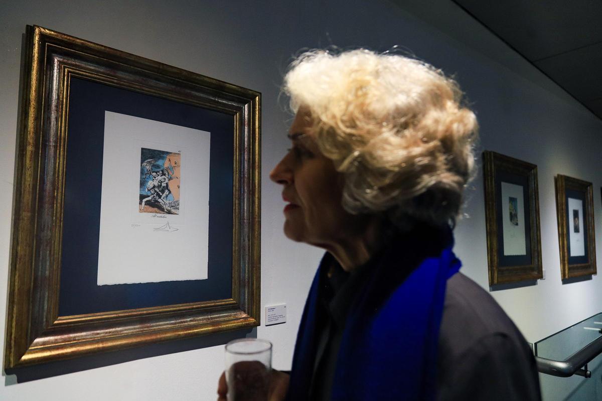 Una dona mirant una obra de Dalí exposada a la mostra.