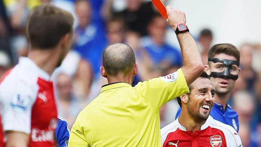 El árbitro Mike Dean muestra la tarjeta roja a Santi Cazorla.