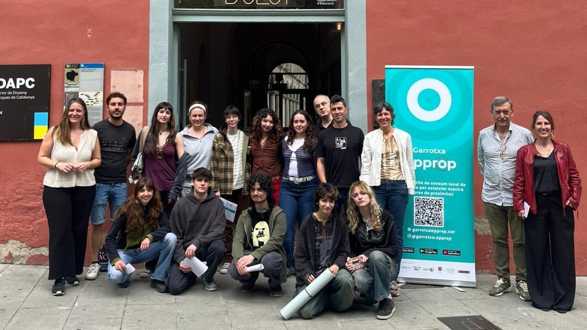 Alumnes i responsables de Garrotxa Approp, davant l’Escola d’Art d’Olot, durant la presentació de la nova mascota de l’app de consum local