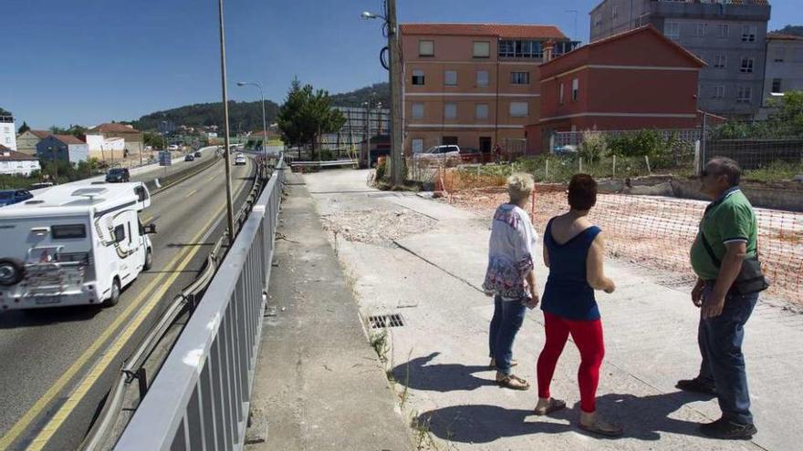 Tres vecinos miran al edificio en el que Audasa pide la expropiación de un garaje. // Marcos Canosa