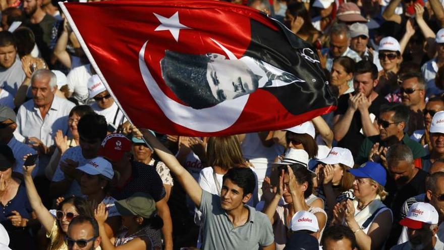 Un manifestante, con una bandera turca con el rostro de Ataturk.