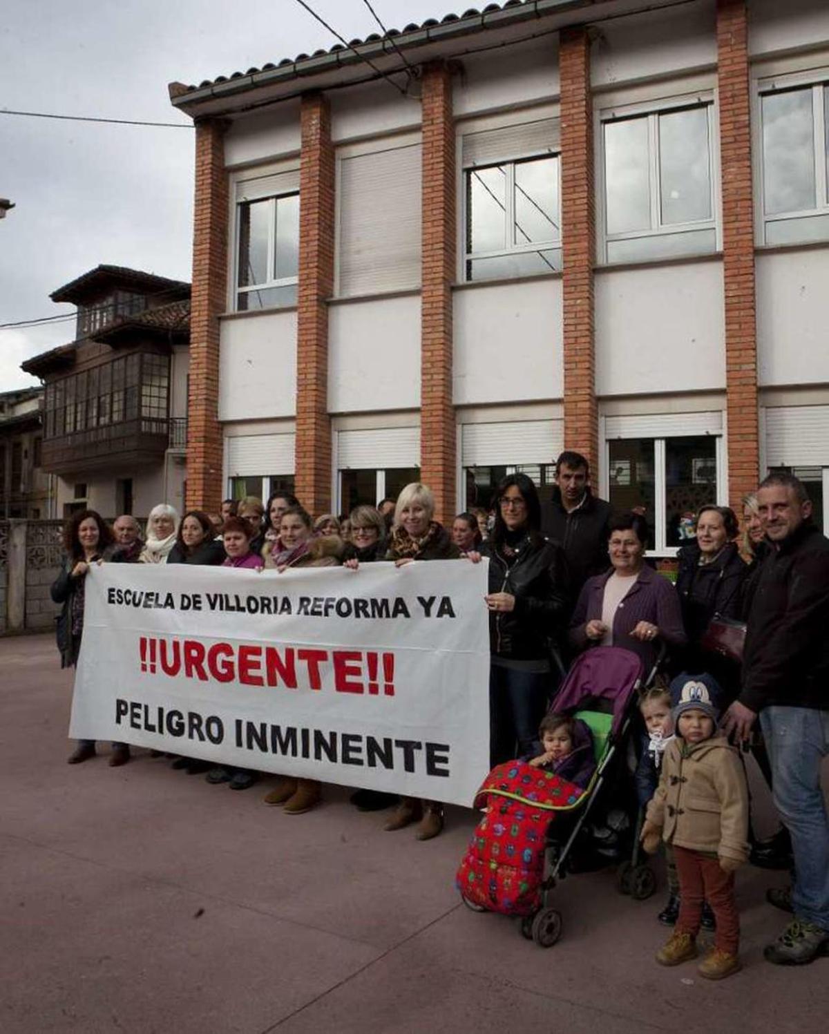 Padres de alumnos del colegio de Villoria, con la escuela detrás.