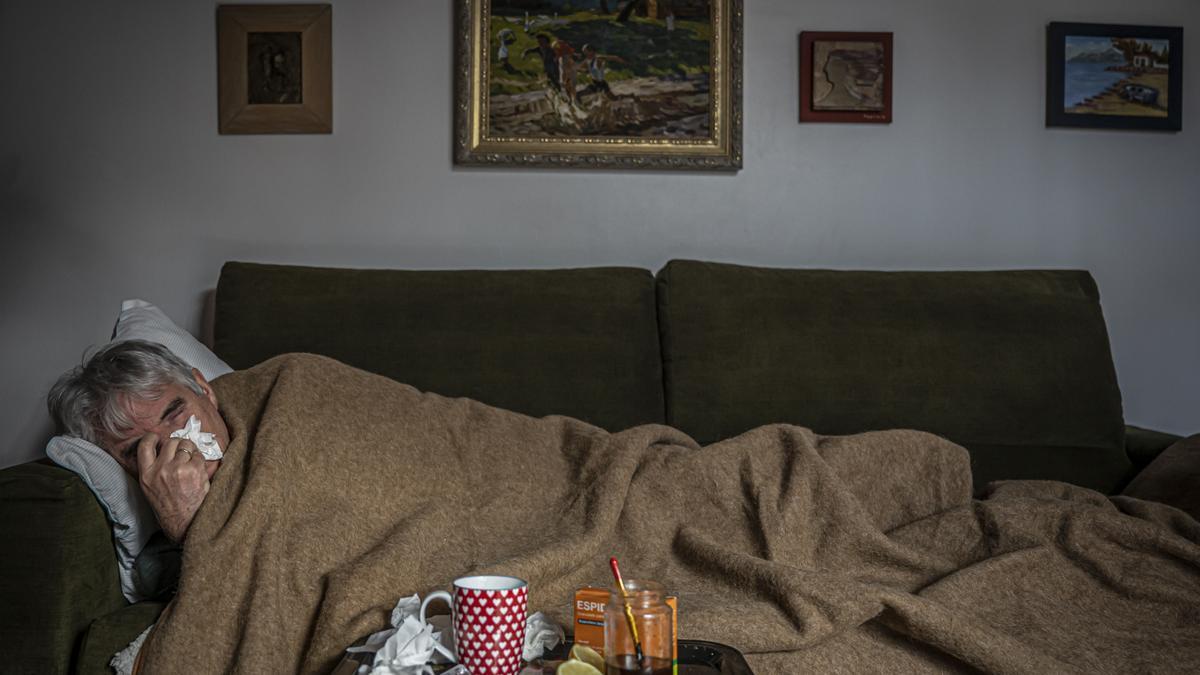 Barcelona 11/12/21 Sociedad. 5 mitos sobre prevenir y curar un resfriado. Adulto con resfriado en el sofa de casa. AUTOR: MANU MITRU.