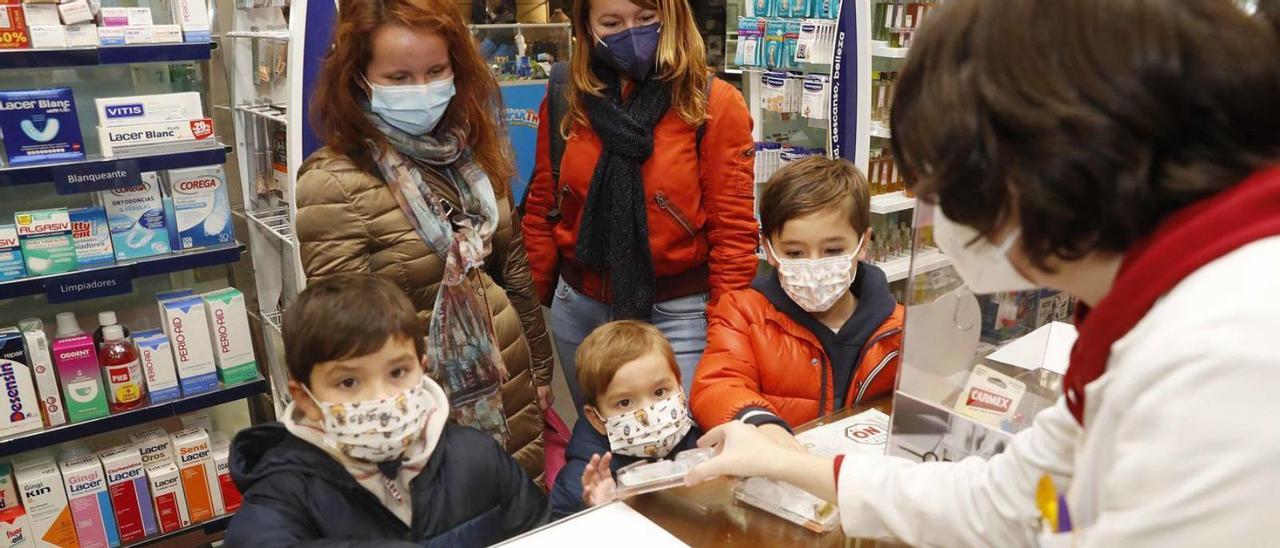 Gabriel y Miguel Fernández y Goyo Mallo, ayer, recogiendo un test en la farmacia Andrés.