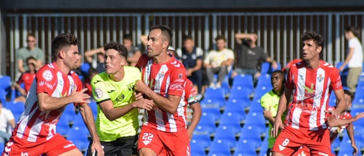 Jugadores de ambos equipos esperan en el área del Don Benito el saque de una falta.