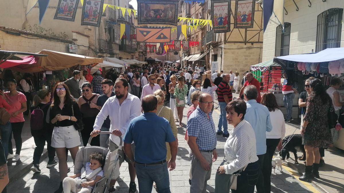 Toresanos y visitantes recorren el mercado medieval en el entorno de la Colegiata