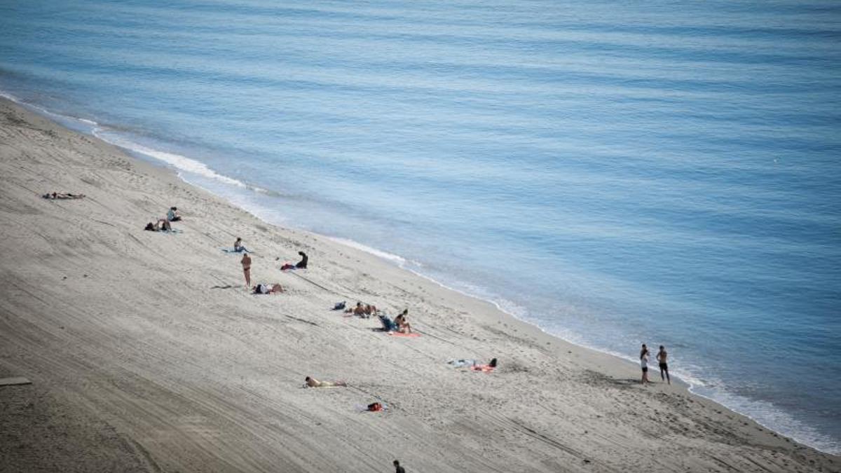 Varias personas acuden a la Playa del Zapillo de Almería para hacer frente a las inusuales temperaturas registradas este enero.