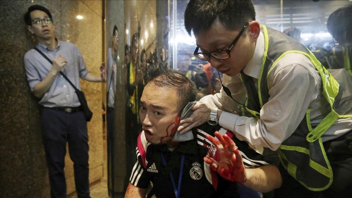 El concejal de distrito Andrew Chiu recibe asistencia sanitaria tras sufrir una agresión en un centro comercial de Hong Kong, este domingo.
