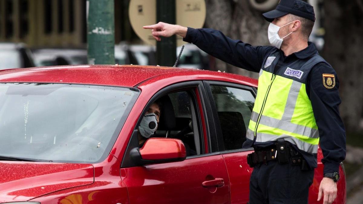 Un agente de la Policía Nacional da indicaciones a un conductor.